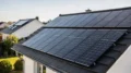Photovoltaik auf dem Hausdach mit Solarmodulen und sonnigem Himmel, Thema Solaranlage fürs Eigenheim